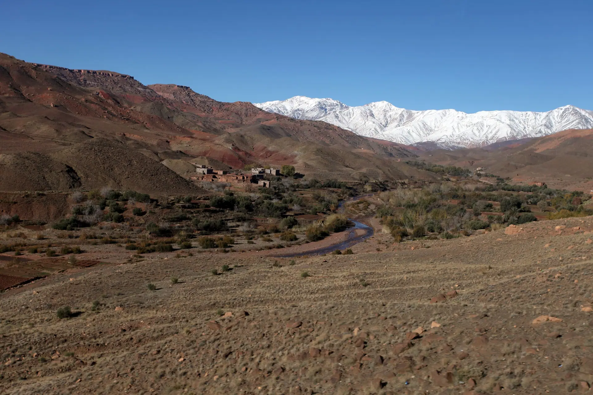 Scenic view of the Atlas Mountains with snow caps and a desert landscape in Ouarzazate, Morocco.