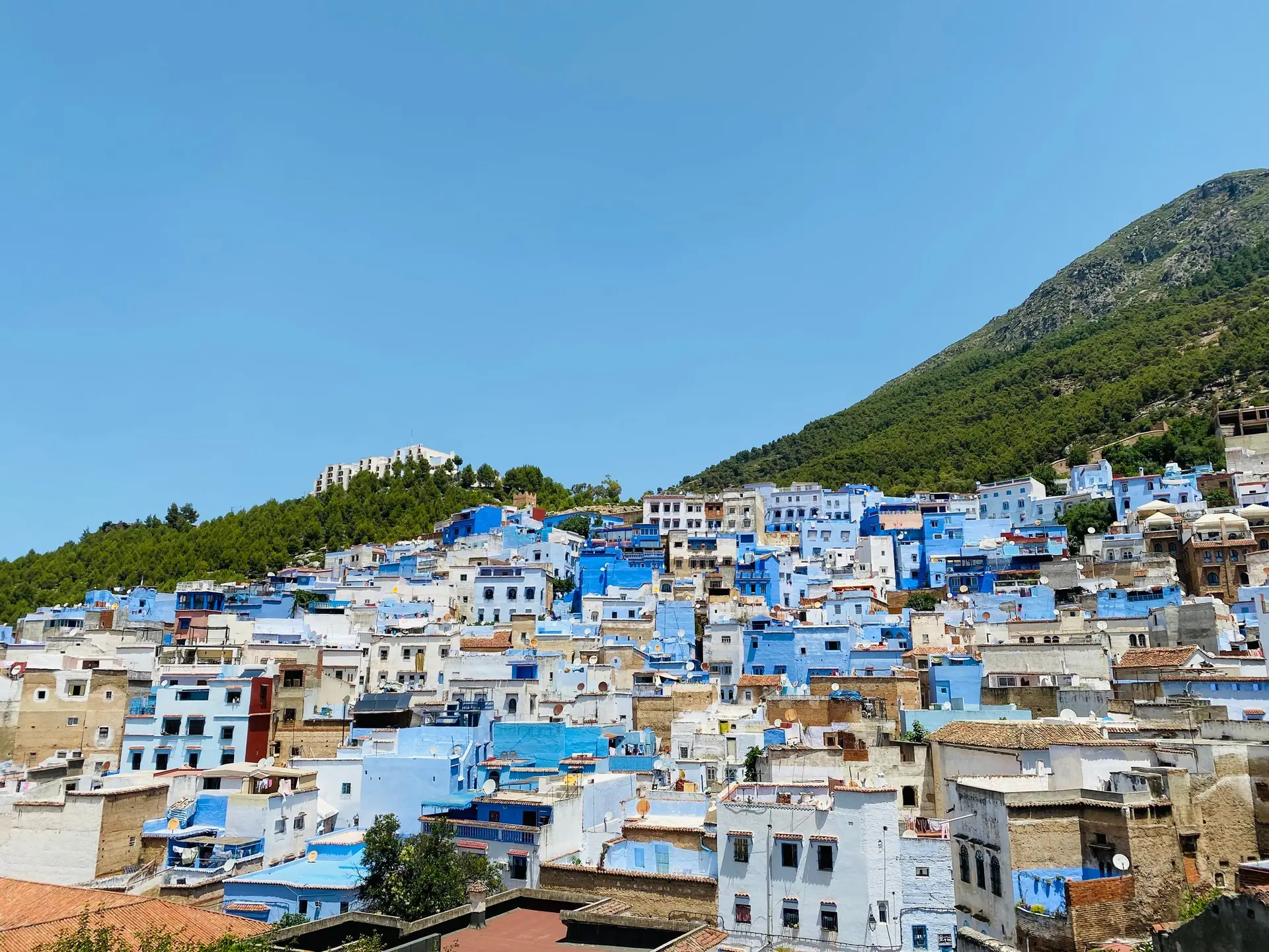 Explore the vibrant, blue-painted townscape of Chefchaouen under a clear sky.