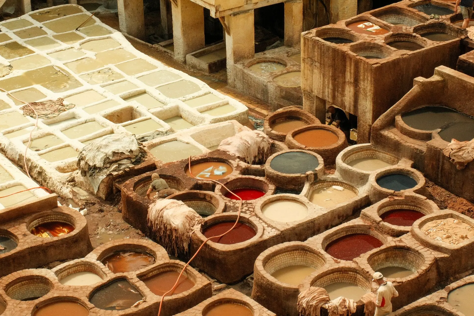 A vibrant aerial view of the traditional tanneries in Fes, Morocco, showcasing the dyeing process.