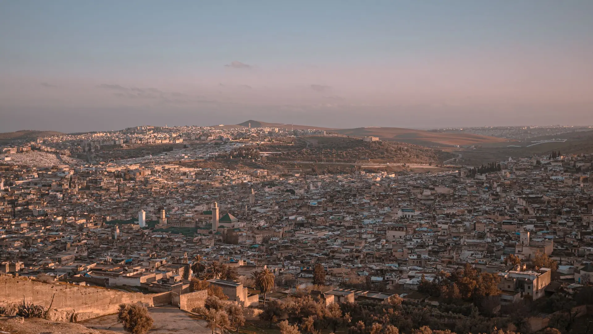 Stunning aerial view of Fes, Morocco showcasing the city's expansive cityscape at sunset.
